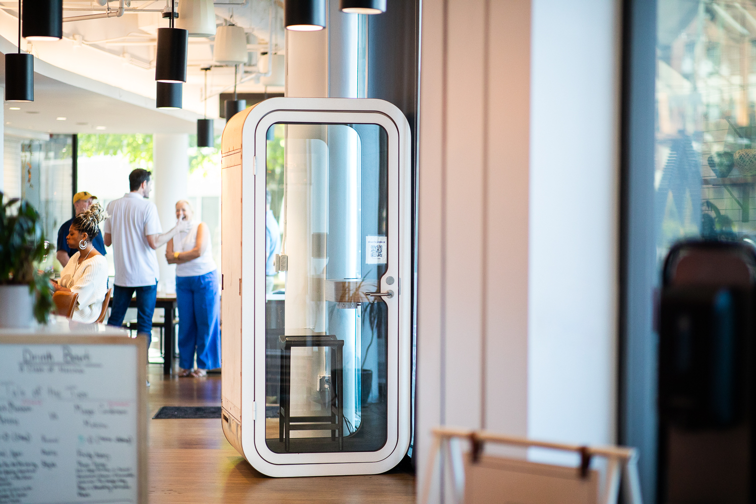 A modern work pod inside a bustling coffee shop